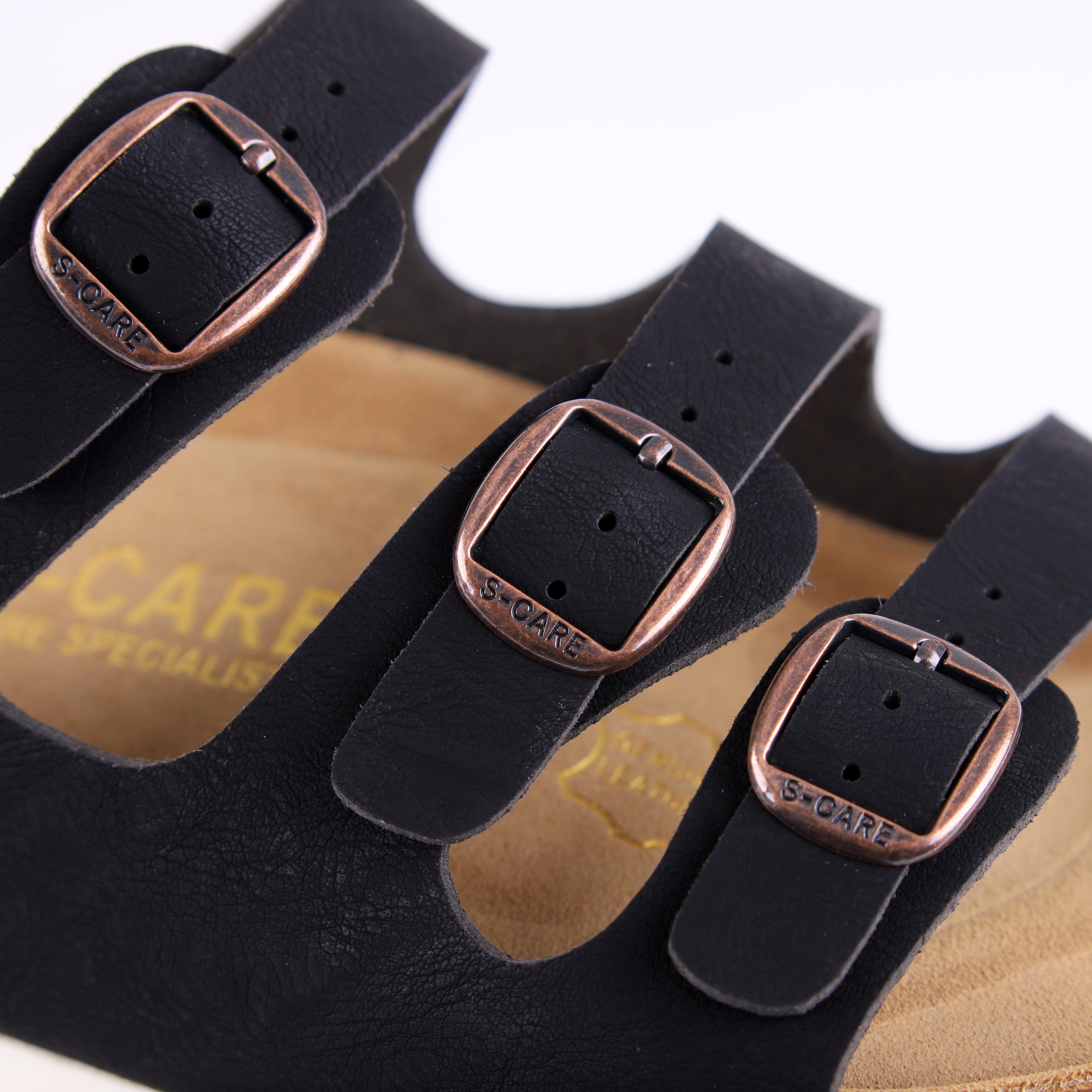 Close-up of S-CARE Muscat Sandals in black, focusing on the texture, stitching, and buckle details.