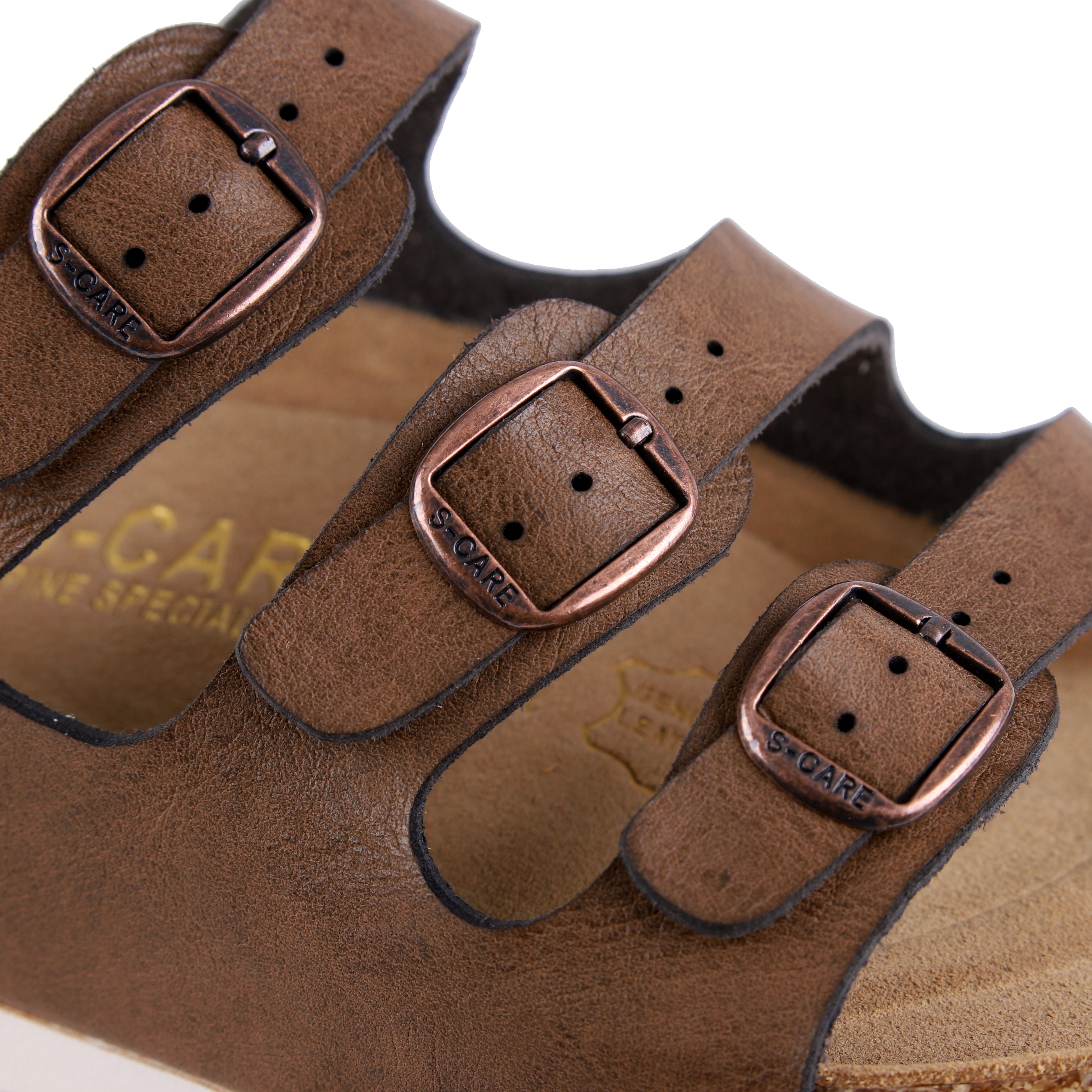 Close-up of S-CARE Muscat Sandals in brown, focusing on the texture, stitching, and buckle details.