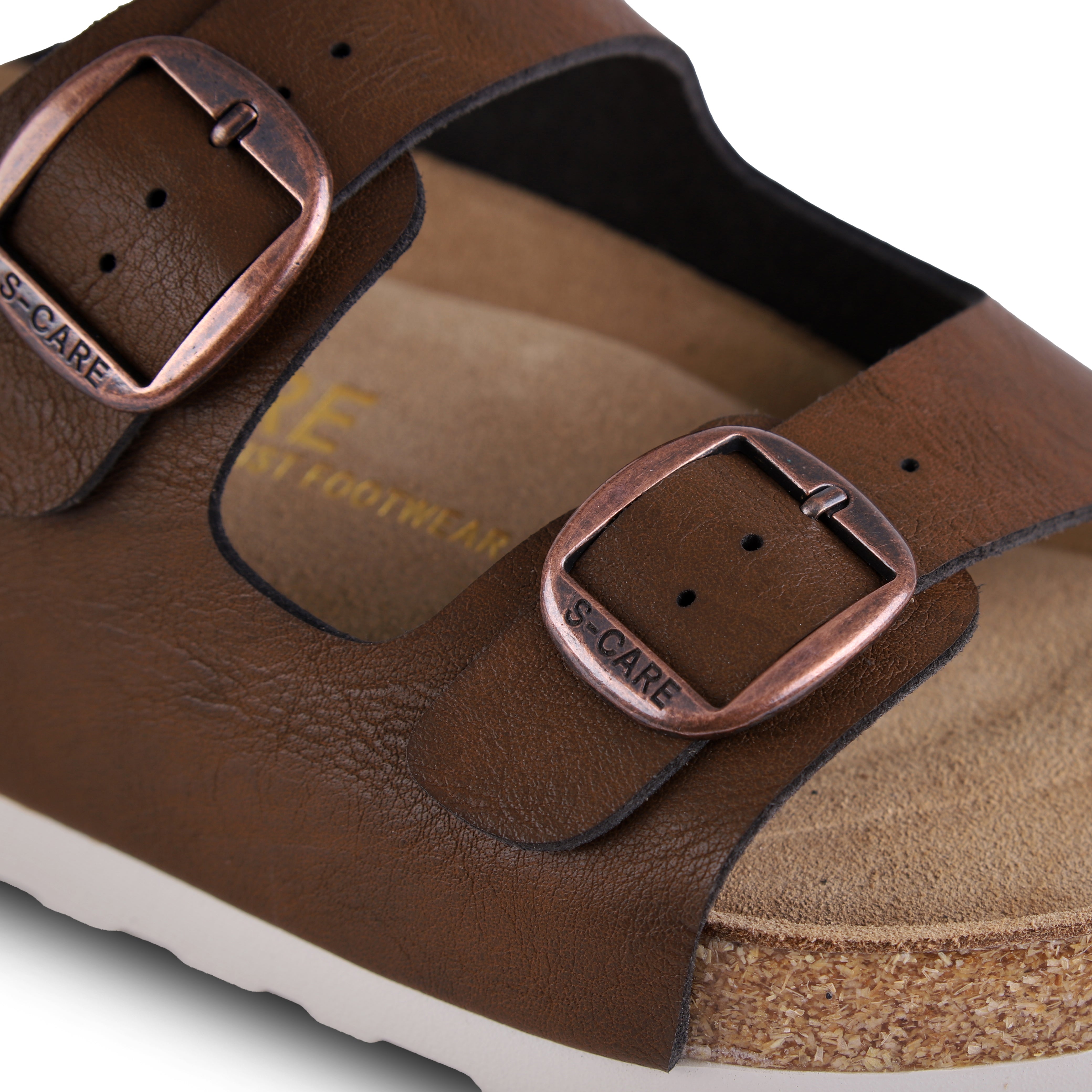 Close-up of S-CARE Doha Sandals in brown, capturing the grainy texture, fine stitching, and side buckle.